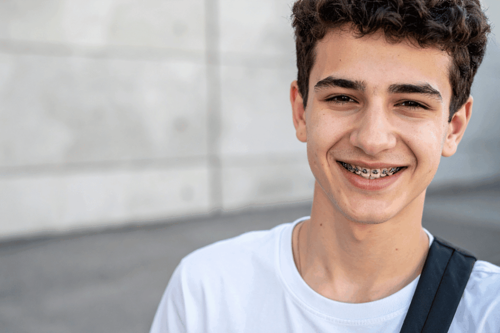 Teen smiling with traditional metal braces